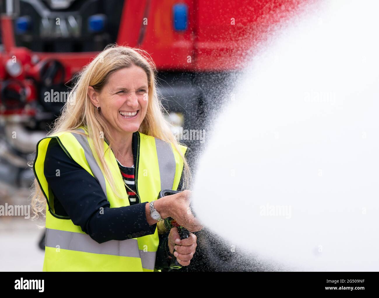 Kim Leadbeater, le candidat travailliste à l'élection partielle Batley et Spren, utilise un tuyau d'incendie lors d'une visite à Angloco, qui fabrique des moteurs d'incendie et des véhicules de secours utilisés dans tout le pays et dans le monde, alors qu'il est sur la piste de campagne avant l'élection partielle du 1er juillet. Date de la photo: Jeudi 24 juin 2021. Banque D'Images