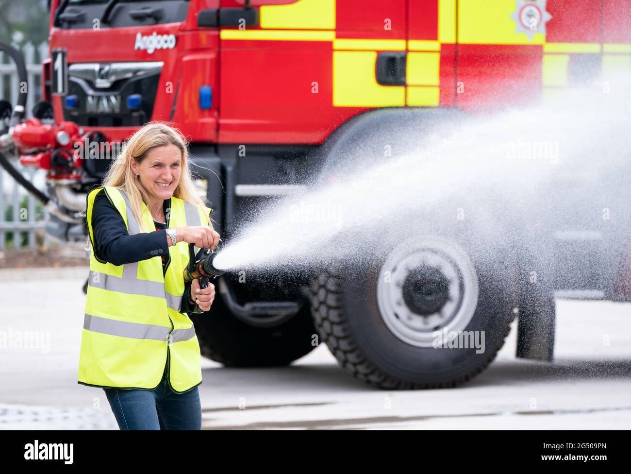 Kim Leadbeater, le candidat travailliste à l'élection partielle Batley et Spren, utilise un tuyau d'incendie lors d'une visite à Angloco, qui fabrique des moteurs d'incendie et des véhicules de secours utilisés dans tout le pays et dans le monde, alors qu'il est sur la piste de campagne avant l'élection partielle du 1er juillet. Date de la photo: Jeudi 24 juin 2021. Banque D'Images