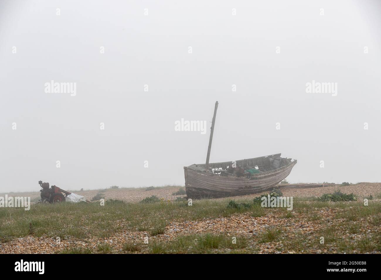 Vieux bateau de pêche en décomposition vu vers la mer un matin brumeux Dungeness, Romney Marsh, Kent, Angleterre, Royaume-Uni Banque D'Images