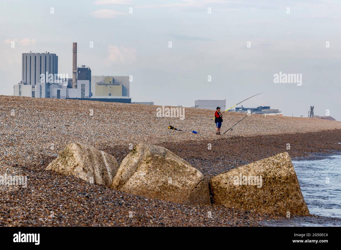 Station nucléaire de Dungeness vue de la plage de Dengemash avec un pêcheur sur le rivage, Romeny Marsh, Kent, Angleterre, Royaume-Uni. Banque D'Images