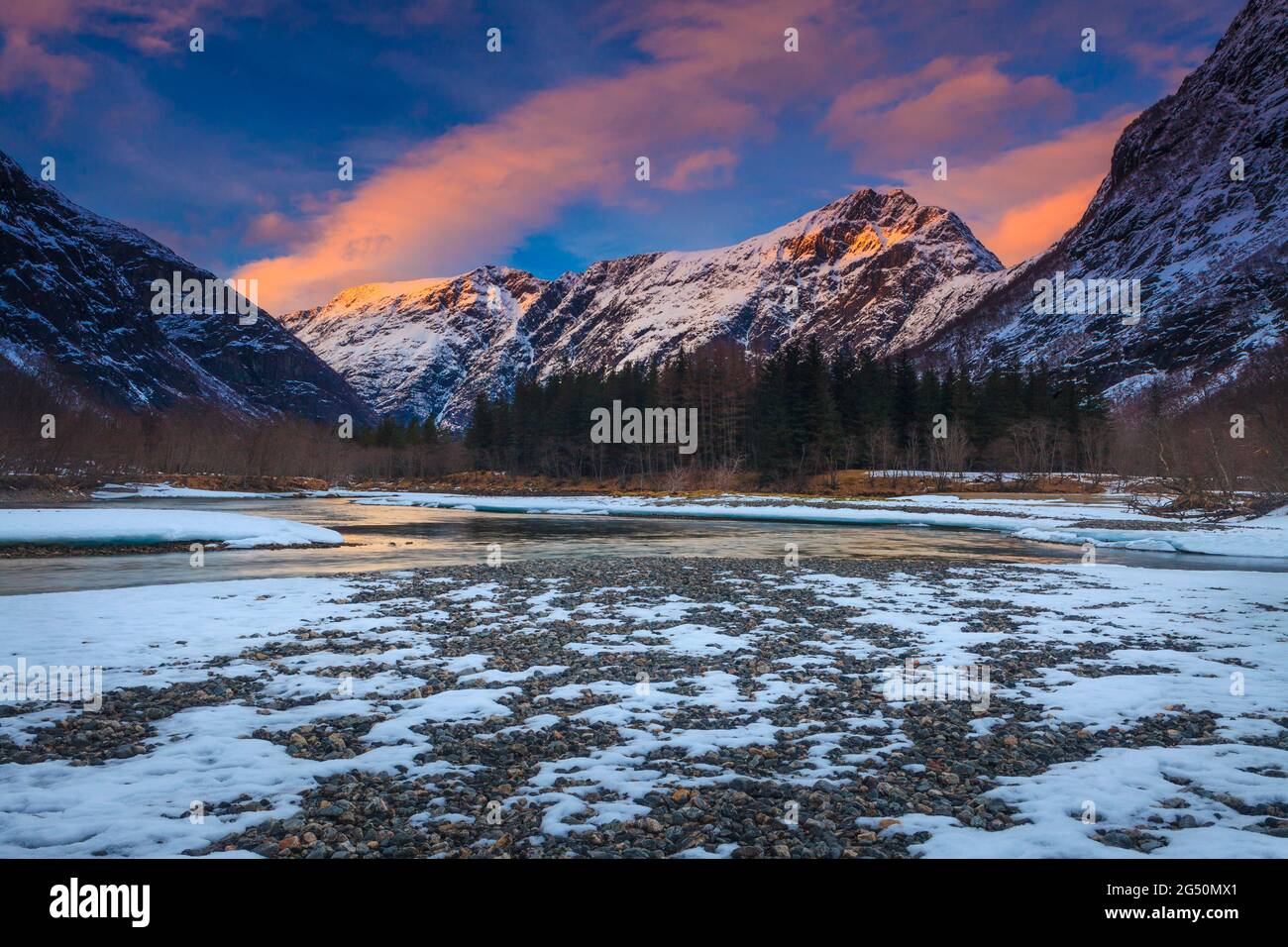 Paysage de l'heure d'or avec un ciel, une montagne et une neige colorés lors d'une soirée d'hiver dans la vallée de Romsdalen, Rauma kommune, Møre og Romsdal, Norvège, Scandinavie. Banque D'Images