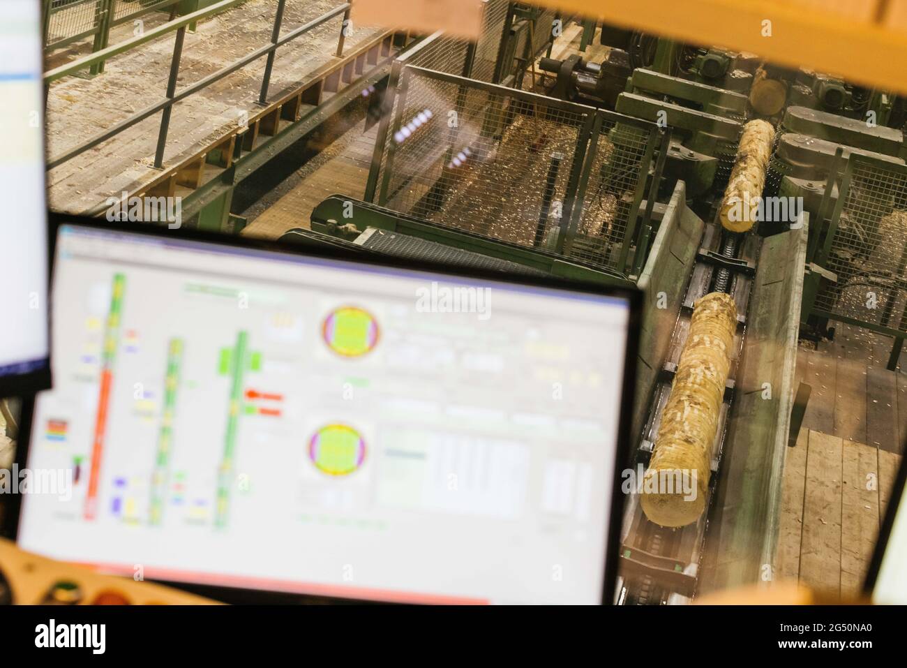 Hausach, Allemagne. 07e juin 2021. Les troncs d'arbres sont transportés sur un tapis convoyeur tandis qu'au premier plan un moniteur d'une ligne de coupe automatisée peut être vu dans les locaux d'une scierie. Les prix du bois sur le marché mondial ont fortement augmenté ces derniers temps, et ce changement se fait également sentir dans les Scieries du sud-ouest. Credit: Philipp von Ditfurth/dpa/Alay Live News Banque D'Images
