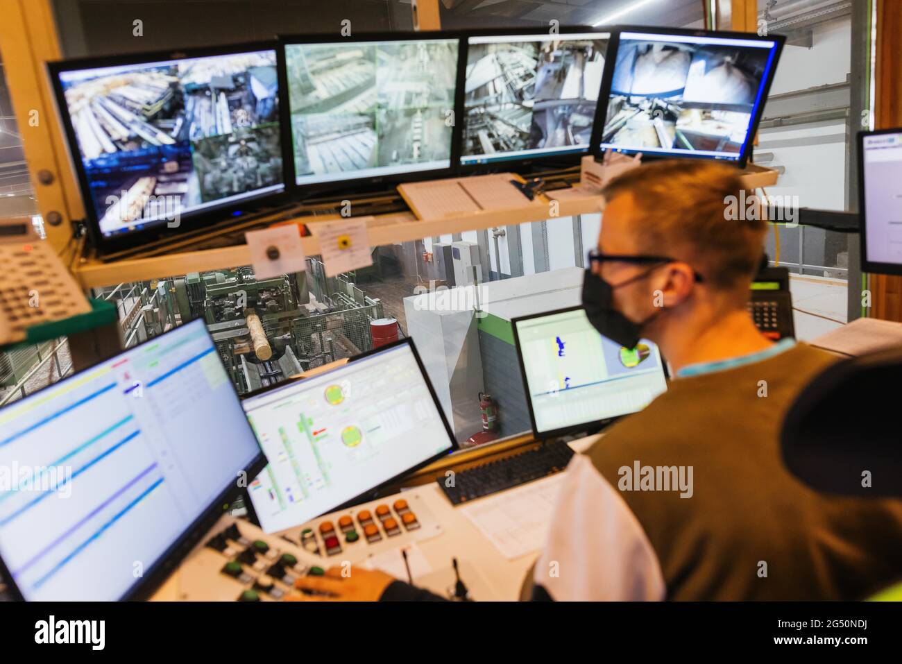 Hausach, Allemagne. 07e juin 2021. Un employé d'une scierie exploite la ligne de coupe automatisée dans les locaux d'une scierie tandis qu'un tronc d'arbre est transporté sur un tapis roulant en arrière-plan. Les prix du bois sur le marché mondial ont fortement augmenté ces derniers temps, et ce changement se fait également sentir dans les Scieries du sud-ouest. Credit: Philipp von Ditfurth/dpa/Alay Live News Banque D'Images