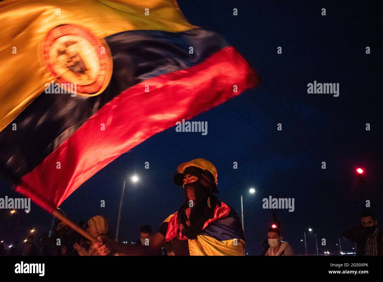 Bogota, Colombie. 23 juin 2021. Un manifestant fait monter un drapeau colombien alors que les manifestations se sont manifestés dans le nord de Bogota, en Colombie, le 22 juin, après qu'un manifestant ait été décédé dans un cas d'abus d'autorité de la police lors d'affrontements avec la police anti-émeute de Colombie (ESMAD) le 22 juin 2021. Crédit : long Visual Press/Alamy Live News Banque D'Images