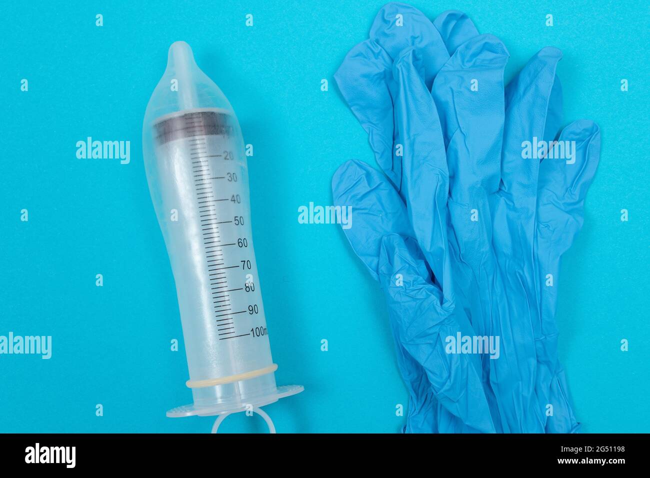 Save Vaccine, anti-vaccination concept - seringue dans un condom sur la table bleue en clinique ou à l'hôpital. Méfiance à l'égard de la vaccination. Immunité naturelle. Scepticisme à propos du vaccin. Liberté et droits de l'homme Banque D'Images