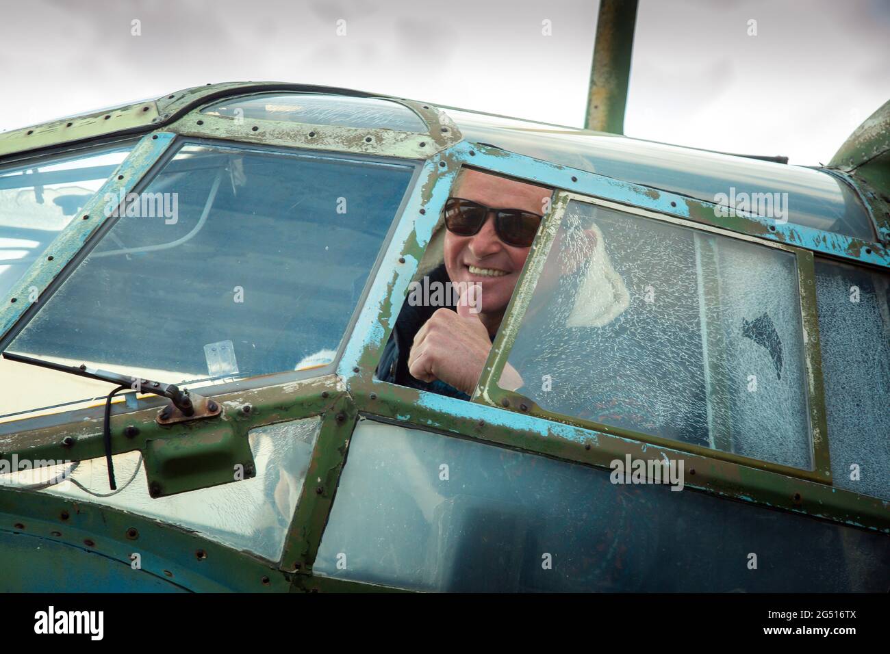 Un homme d'âge moyen à bord d'un ancien avion soviétique abandonné. L'homme regarde par la fenêtre. Banque D'Images