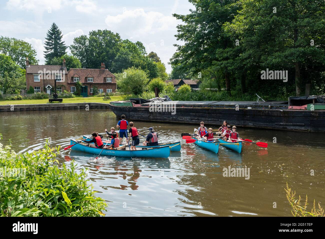 Dapdune Wharf à Guildford, Surrey, Angleterre, Royaume-Uni, avec des enfants qui apprennent à faire du canoë sur le Wey navigation pendant l'été Banque D'Images