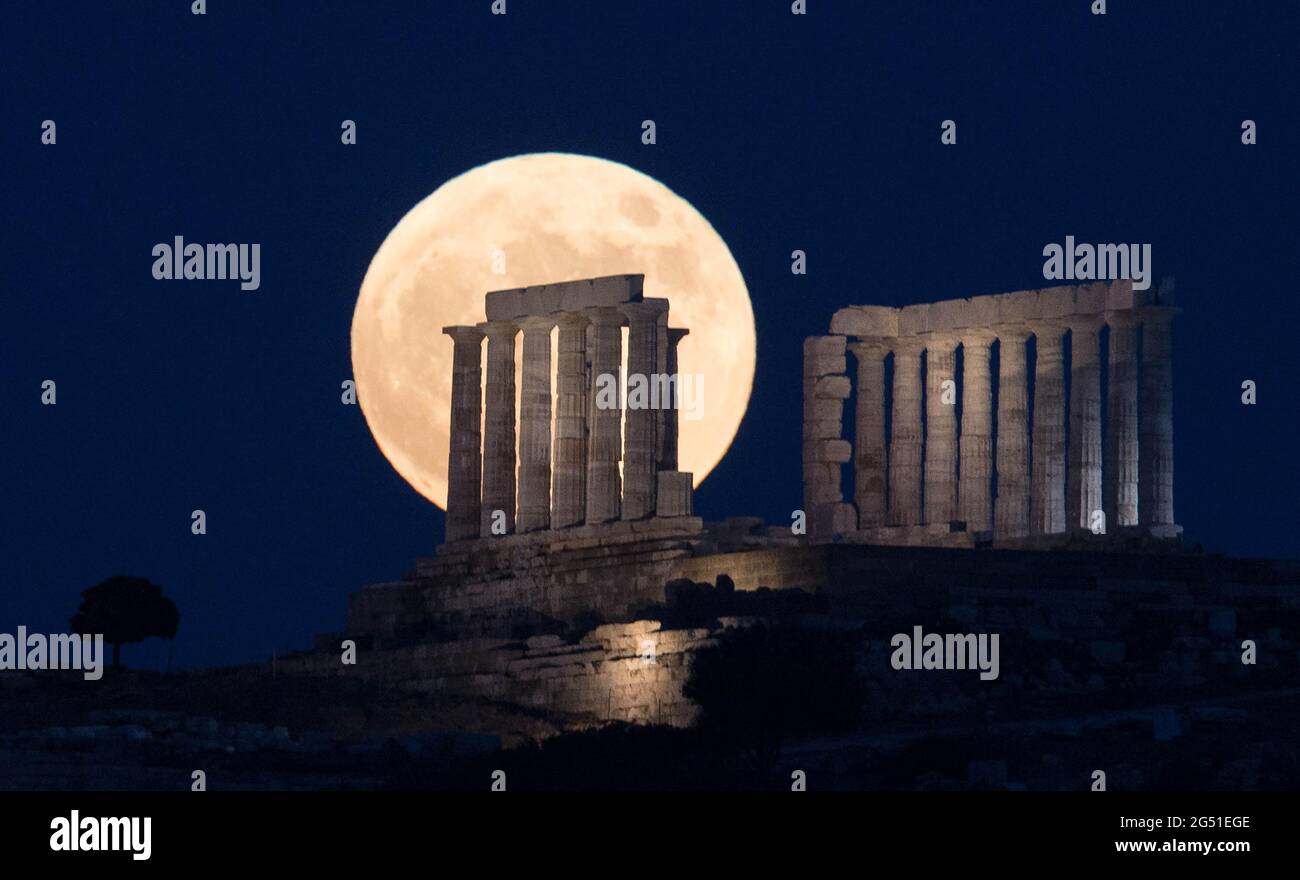 Cap Sounion, Grèce. 24 juin 2021. La pleine lune s'élève au-dessus du Temple de Poséidon au cap Sounion, à environ 70 km au sud-est d'Athènes, Grèce, le 24 juin 2021. Crédit: Marios Lolos/Xinhua/Alamy Live News Banque D'Images