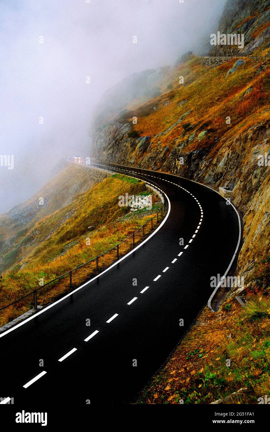 Route sur le flanc de montagne qui disparaît dans le brouillard, Suisse Banque D'Images