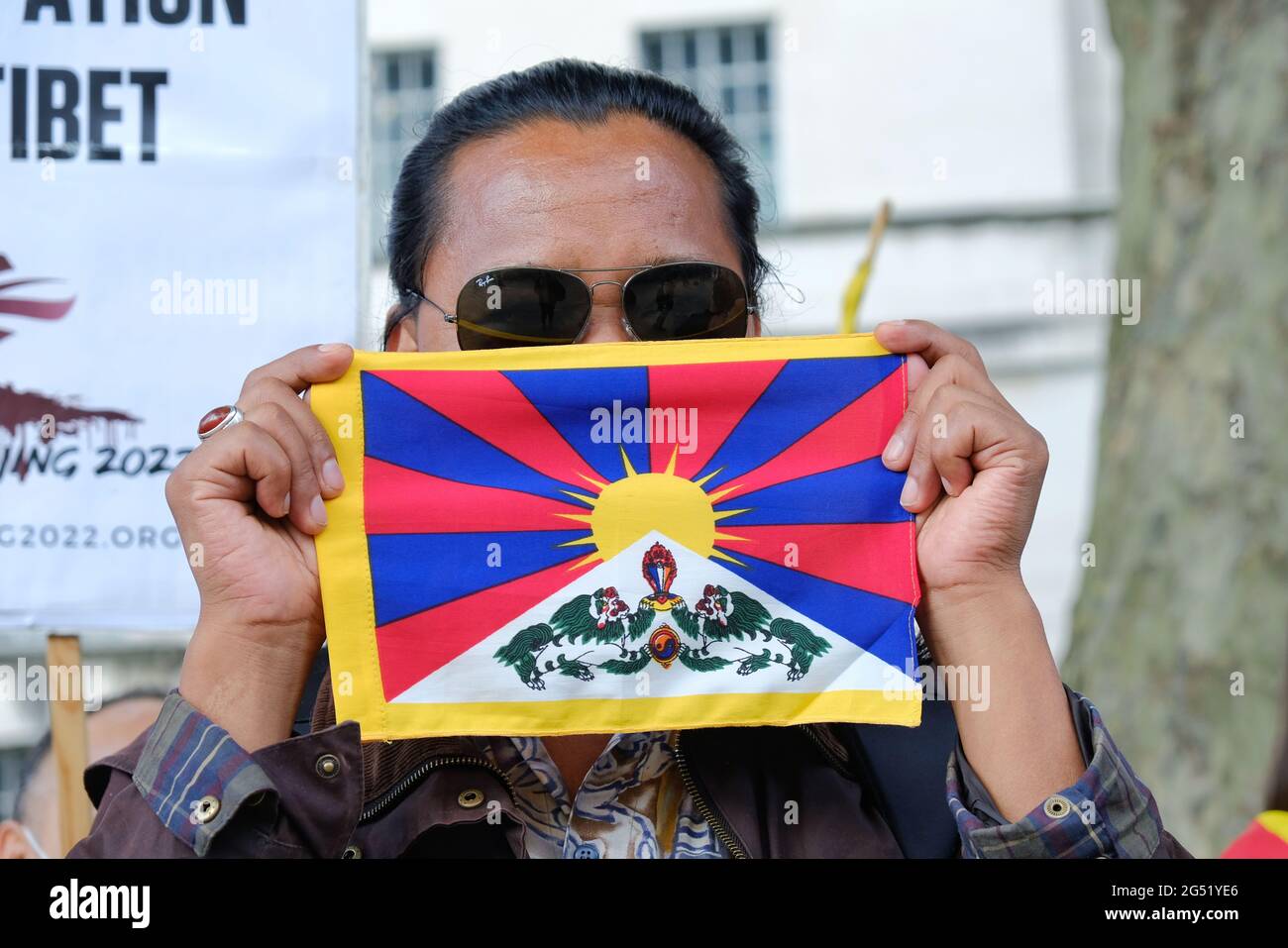 Un homme porte un petit drapeau tibétain lors d'une manifestation appelant au boycott des Jeux Olympiques d'hiver de Beijing sur les violations des droits de l'homme commises. Banque D'Images
