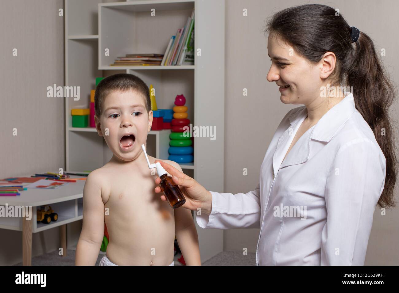 Un Pediatre Ou Une Infirmiere Et Un Garcon De 3 4 Ans Spray Pour La Gorge Traitement De La Pharyngite Stomatite Ou Muguet Chez Les Enfants Photo Stock Alamy