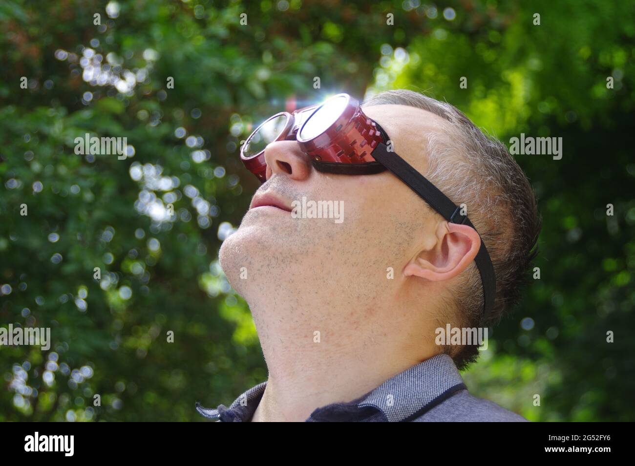 Homme regardant un soleil éclipse à travers des lunettes de sécurité. En  regardant le phénomène solaire Photo Stock - Alamy