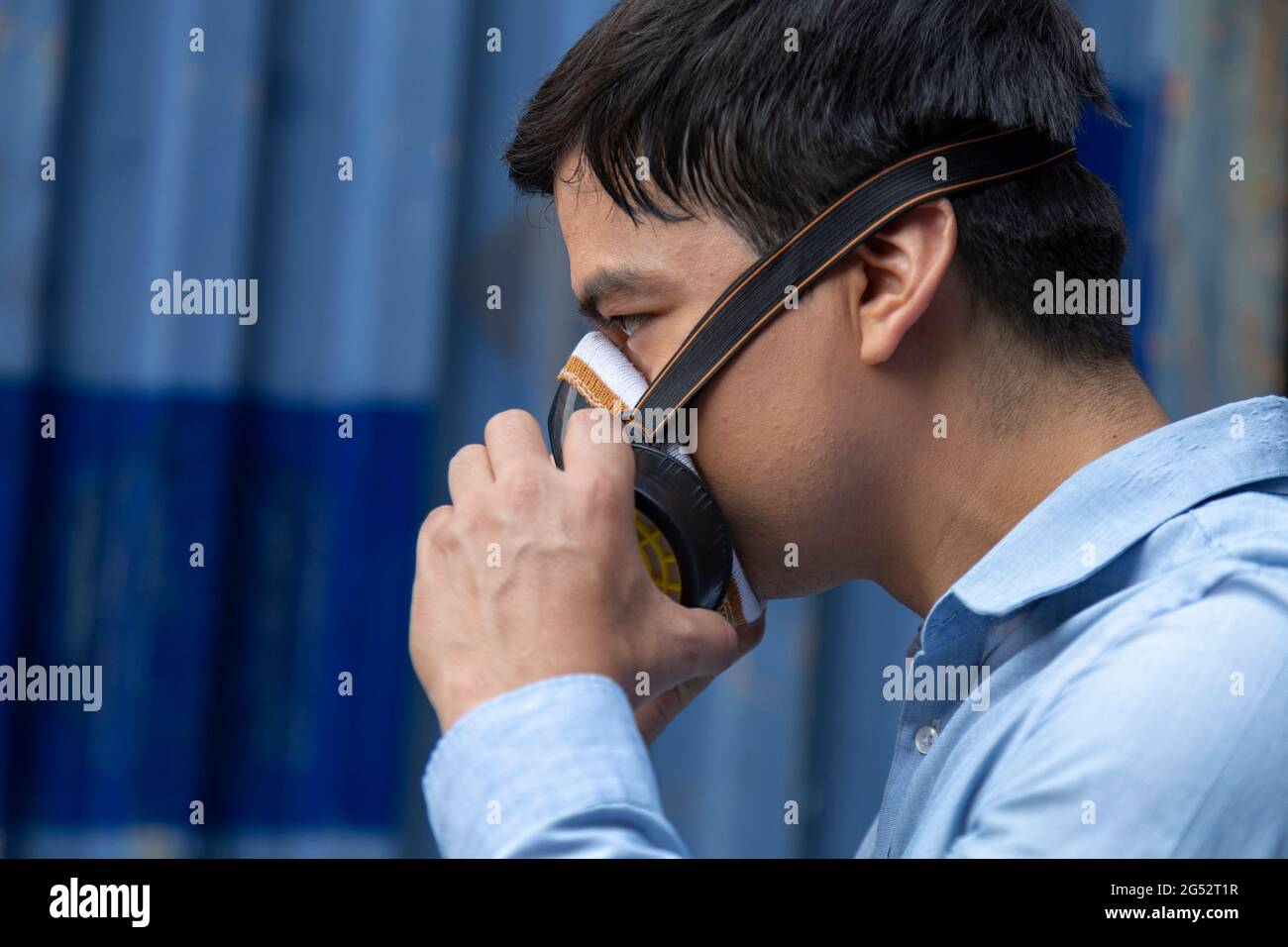 un jeune homme d'affaires portant un demi-masque respiratoire pour protéger le coronavirus ou la pandémie de covid-19 et la pollution de l'air des pm2,5 contre la circulation et la fabrication Banque D'Images