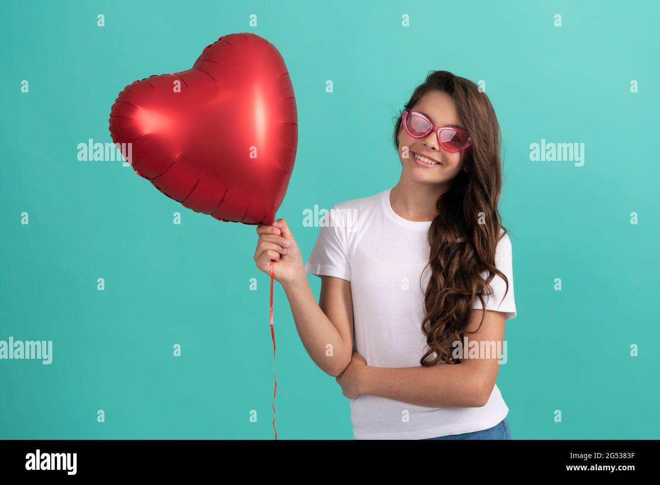 bonne adolescente dans des lunettes de soleil tenir coeur partie ballon  pour saint valentin symbole amour, fête romantique Photo Stock - Alamy