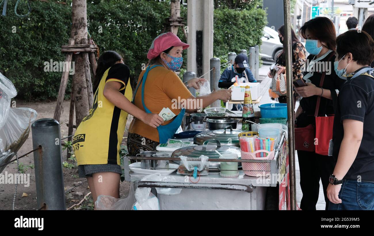 Acheteur et vendeur monnaie authentique changer de mains Klong Toey Market BangkokThailand l'économie de la vente de nourriture les gens achetant le déjeuner Rama 4 intersection Banque D'Images