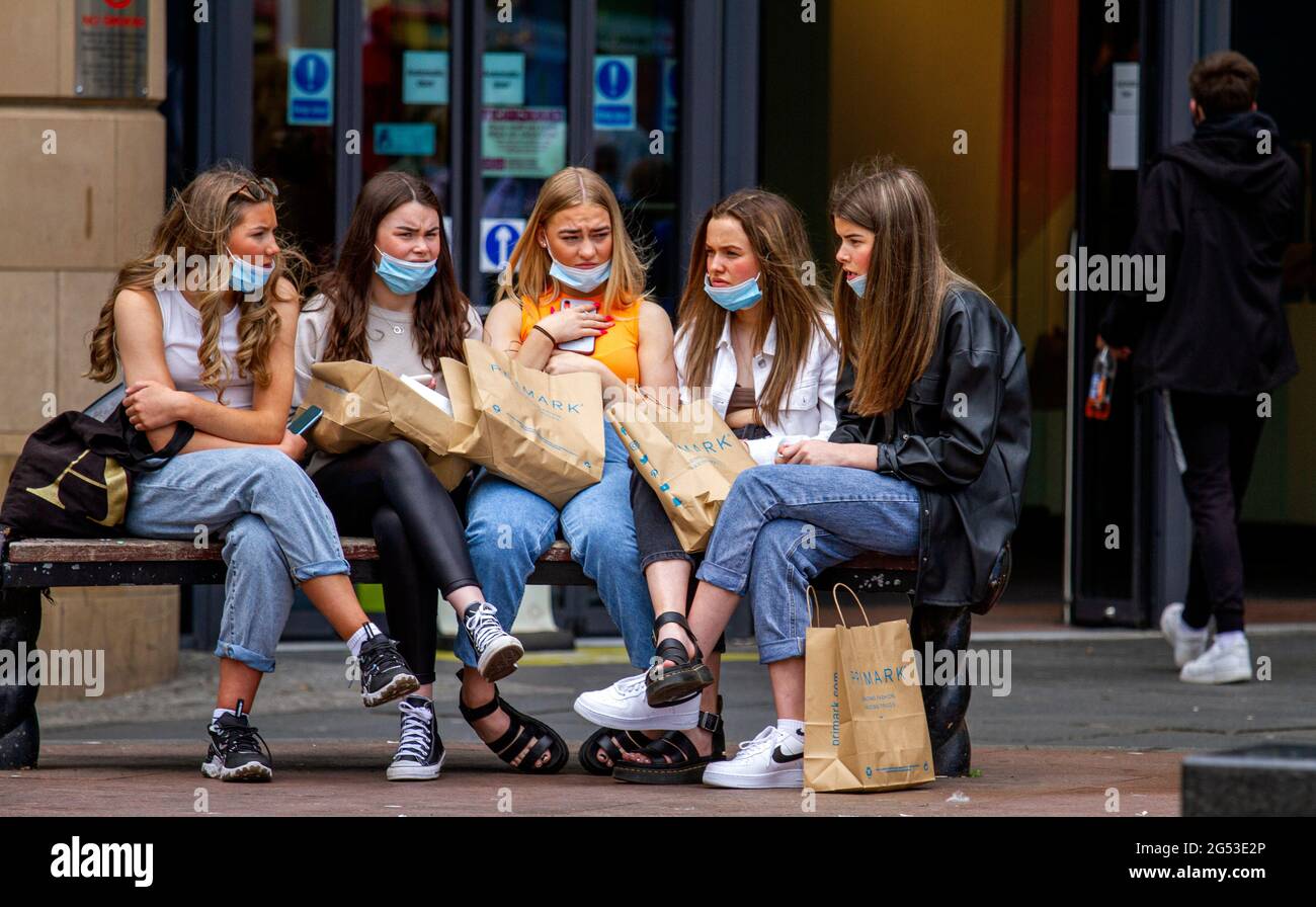 Dundee, Tayside, Écosse, Royaume-Uni. 25 juin 2021. Météo au Royaume-Uni : une journée lumineuse avec une brise fraîche et modérée à travers le nord-est de l'Écosse avec des températures atteignant 15°C. Les écoles écossaises ont maintenant fermé pour les vacances d'été et de nombreux résidents locaux prennent la journée pour profiter du temps et de socialiser avec des amis. Cinq jeunes femmes assises à l'extérieur du centre commercial Overgate après une journée de shopping au magasin de mode Primark dans le centre-ville de Dundee. Crédit : Dundee Photographics/Alamy Live News Banque D'Images