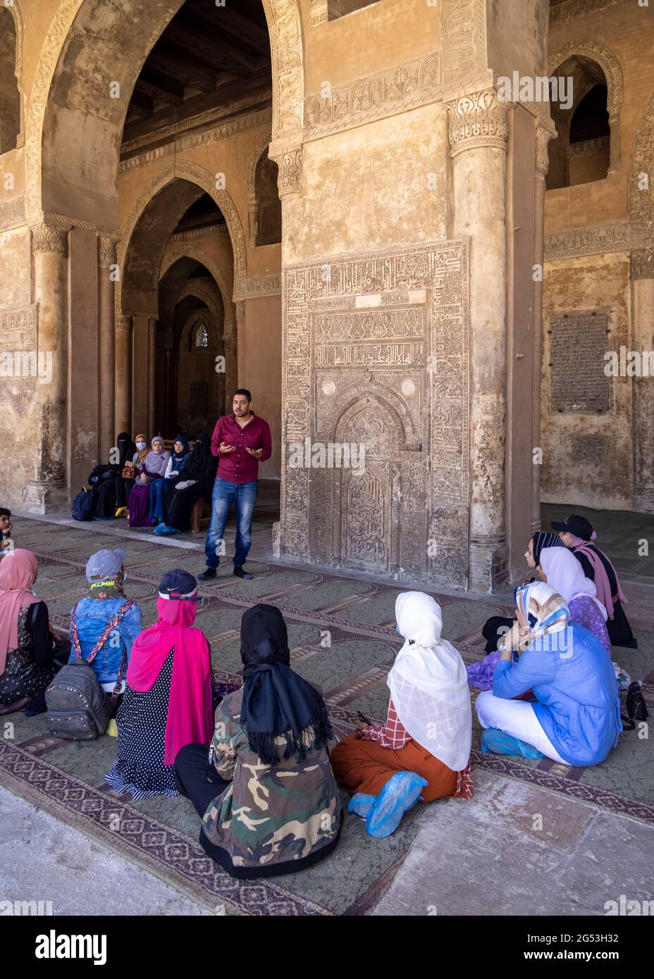 Homme parlant à un groupe de femmes devant le mihrab Fatimide dans la mosquée d'Ibn Tulun, le Caire, Egypte Banque D'Images