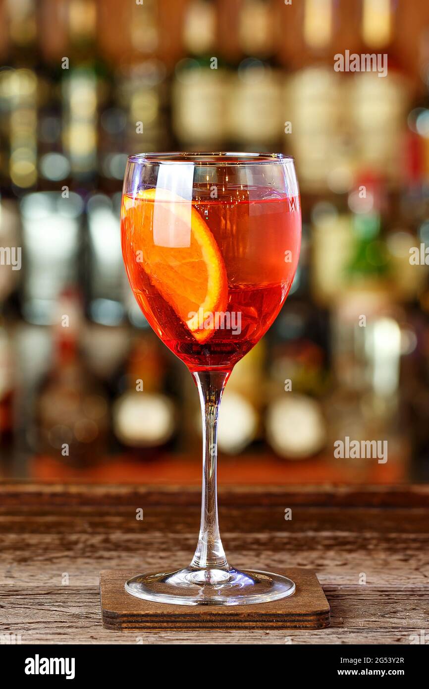 Un apéritif italien léger et rafraîchissant, l'apelol Spritz, est installé au bar dans un restaurant ou dans une discothèque. Cocktail rouge à base de teinture d'Apelol, champagne Banque D'Images