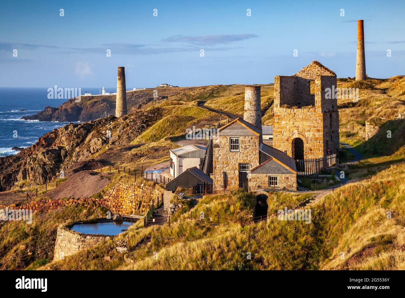 Levant Mine et les moteurs cornish, avec le phare de Pendeen à distance, près de Pendeen dans Cornwall. Banque D'Images