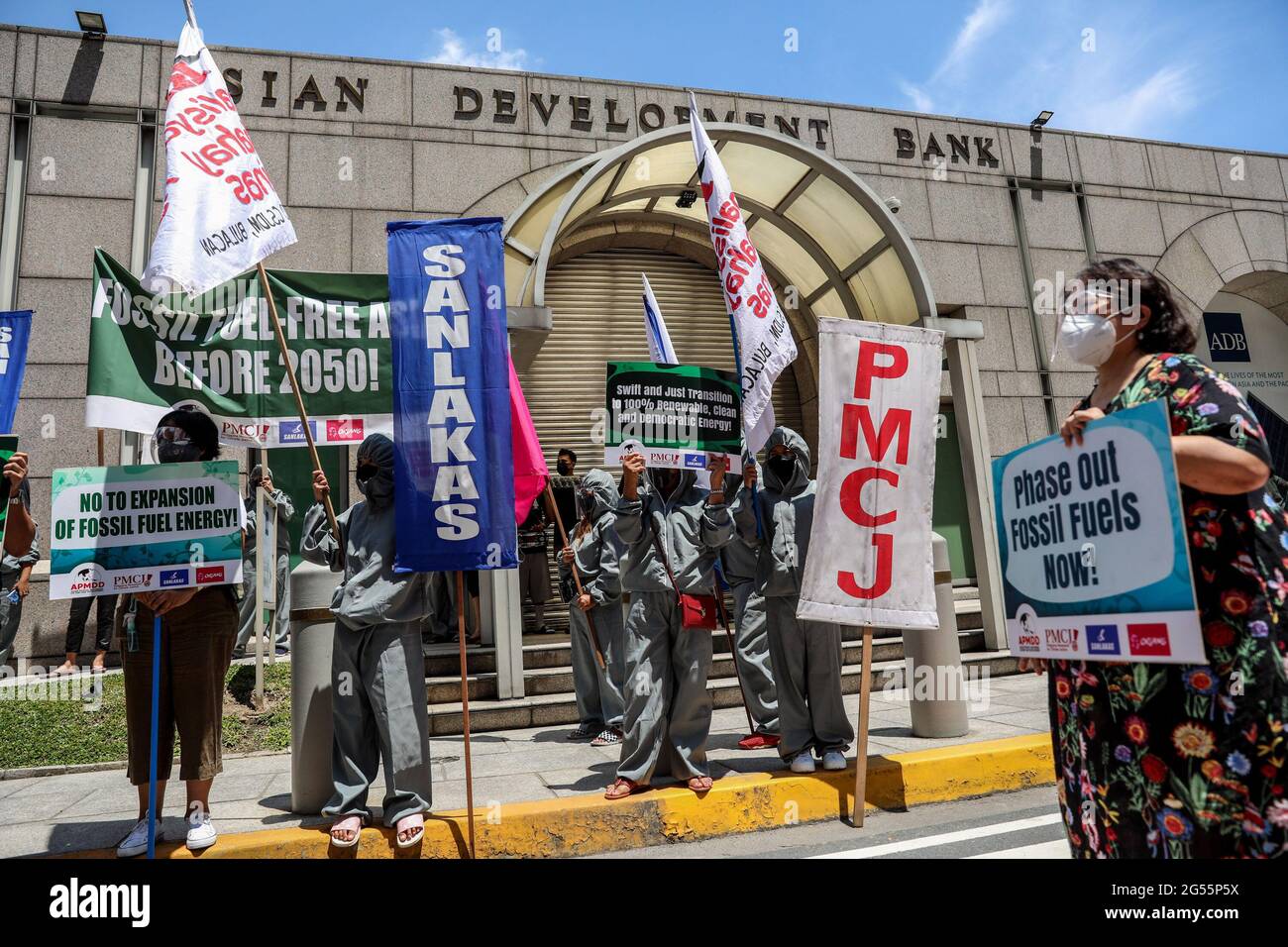 Les activistes du climat vêtus de costumes portent des signes alors qu'ils protestent à l'extérieur du siège de la Banque asiatique de développement (BAD) à Mandaluyong City. Le groupe a appelé la BAD, qui accueille actuellement le Forum sur l'énergie propre en Asie, et les institutions financières participantes à cesser de financer des projets de combustibles fossiles et à faire le passage à l'énergie renouvelable. Metro Manille, Philippines. Banque D'Images