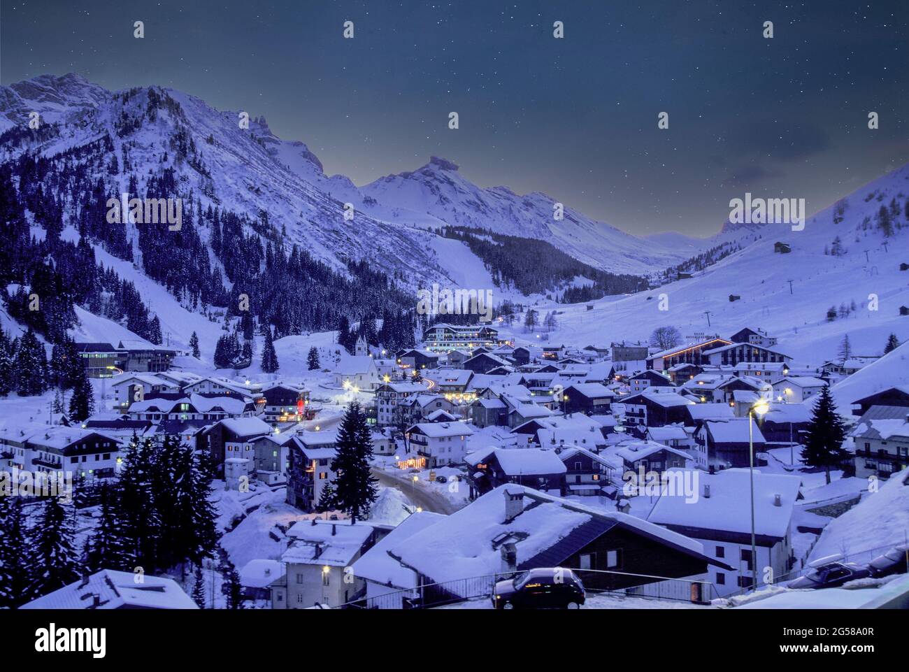Italie, Dolomites, Alta Badia, Village couvert de neige dans la vallée de la montagne au crépuscule Banque D'Images