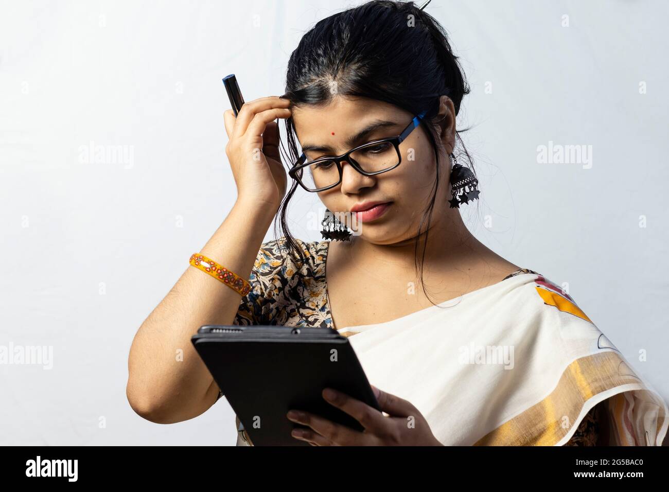Isolé sur fond blanc une femme de bureau indienne en saree travaillant sur une tablette Banque D'Images