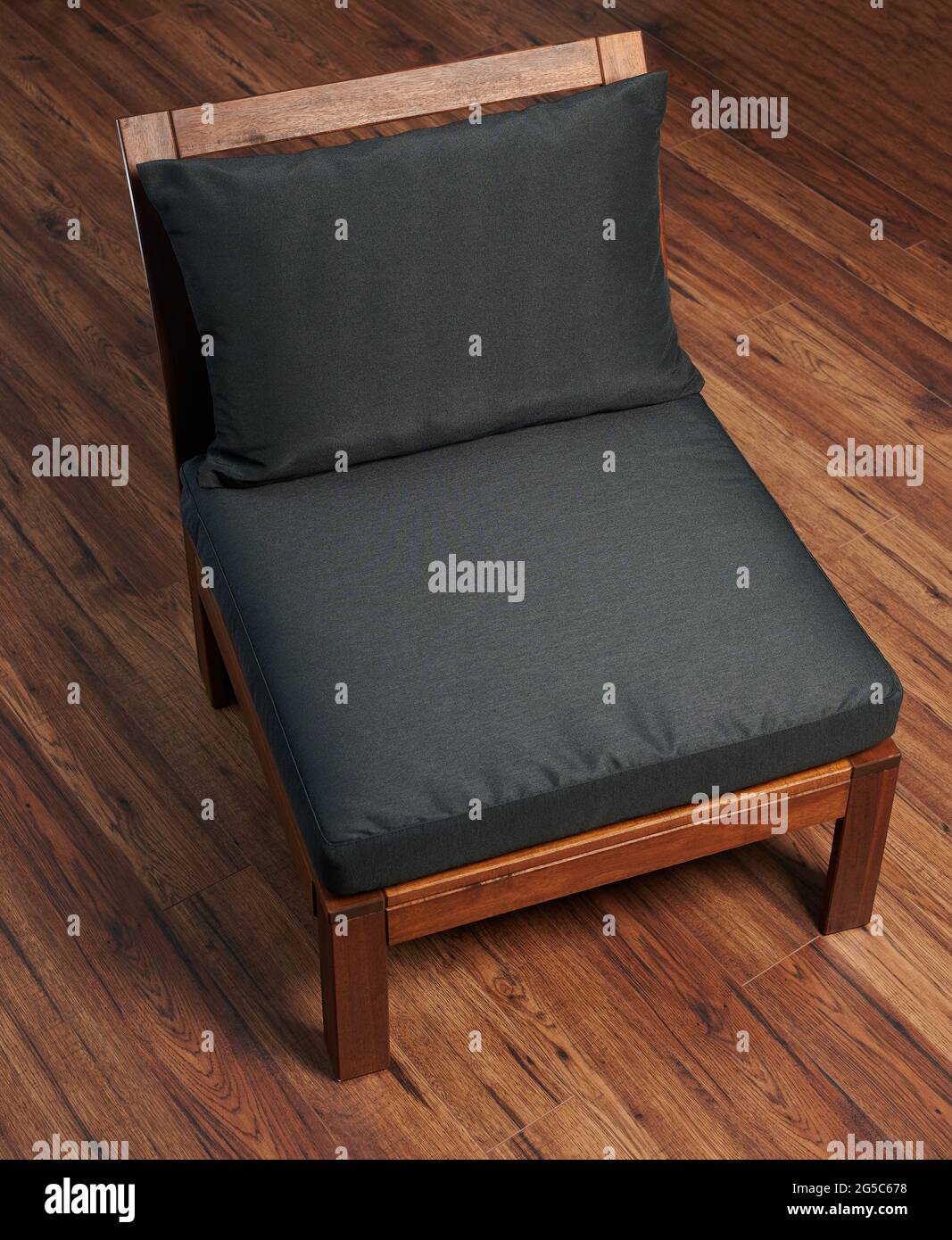 Chaise en bois avec coussin noir sur parquet Banque D'Images