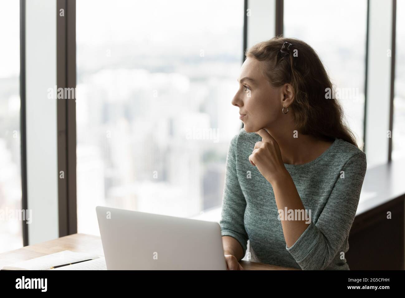 Jeune femme d'affaires pensive regardant à distance, distrait du travail. Banque D'Images