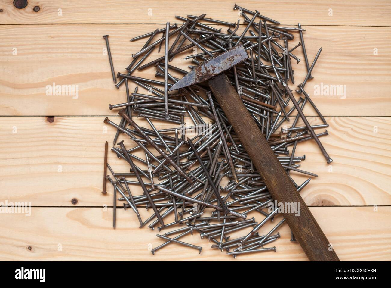 Marteau rétro avec clous sur fond de bois. Espace pour le texte. Vue de dessus. Banque D'Images