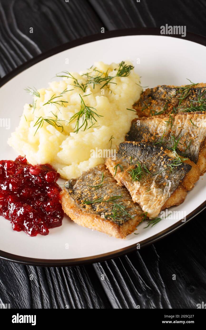 Swedish Stekt stronging ou frit du hareng avec des pommes de terre bouillies et de la confiture de lingonberry dans l'assiette sur la table. Verticale Banque D'Images