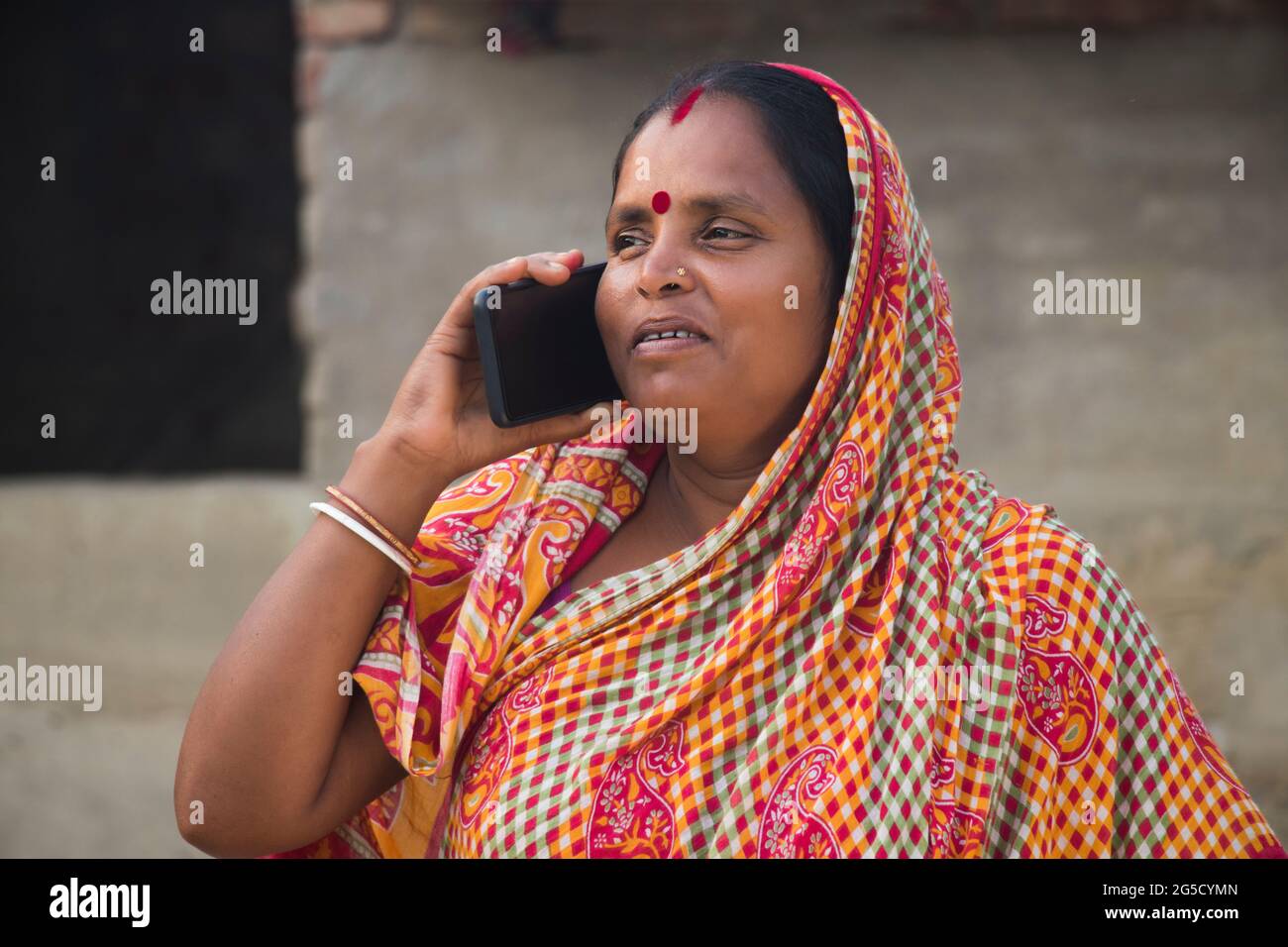 Femme rurale indienne parlant au téléphone intelligent Banque D'Images