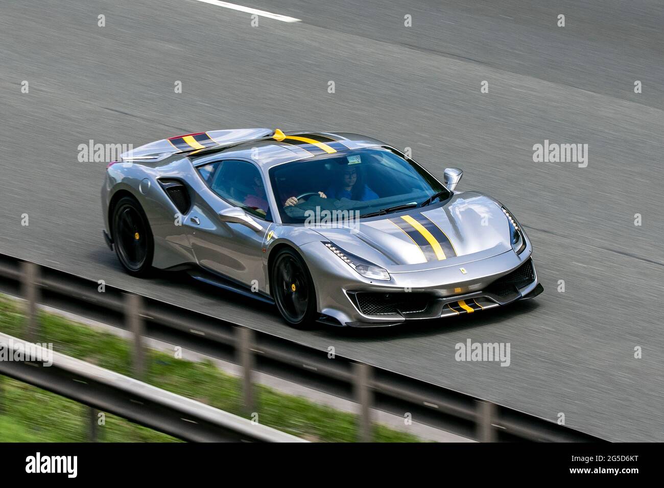 Matte Grey Ferrari 488 Pista avec Yellow Stripes en voiture sur l'autoroute M6 près de Preston à Lancashire, Royaume-Uni Banque D'Images
