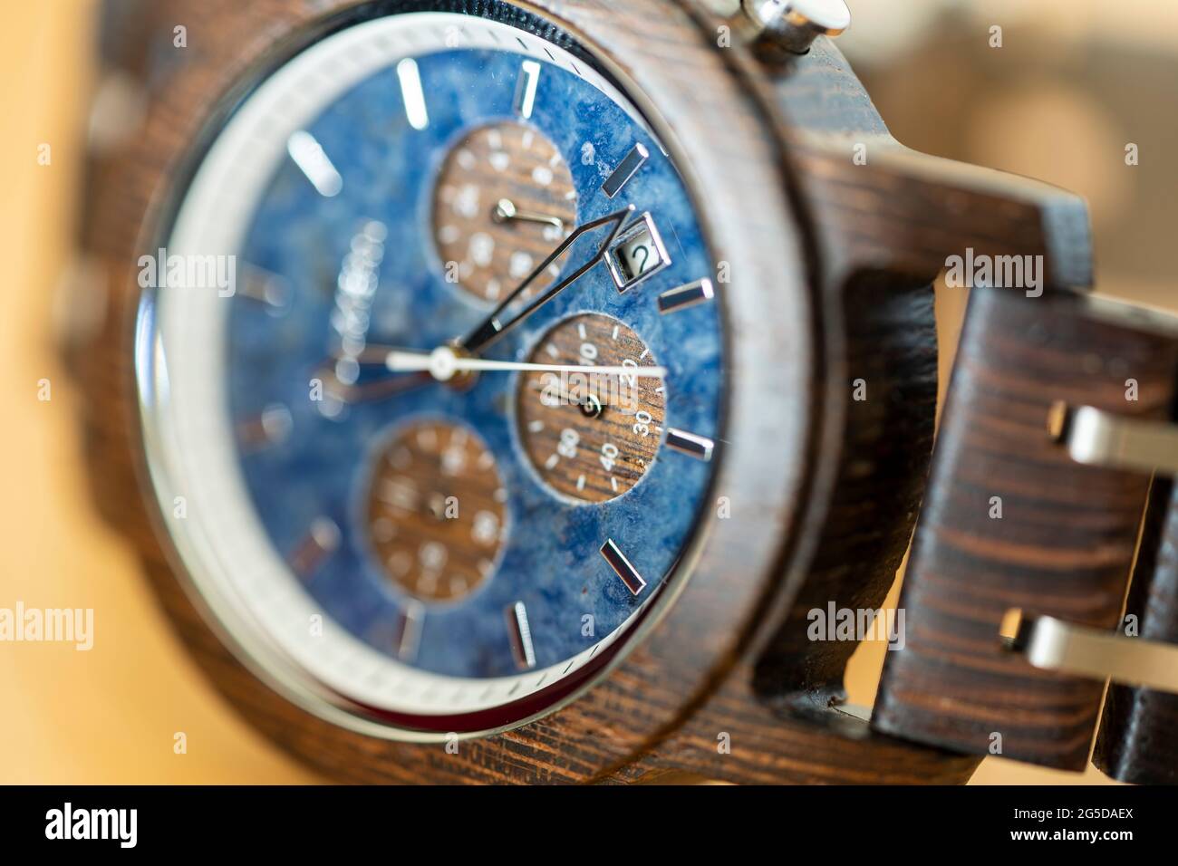 Macro gros plan d'une montre-bracelet Holzkern en bois avec un cadran de montre en pierre naturelle et des aiguilles d'horloge et une sangle en bois Banque D'Images