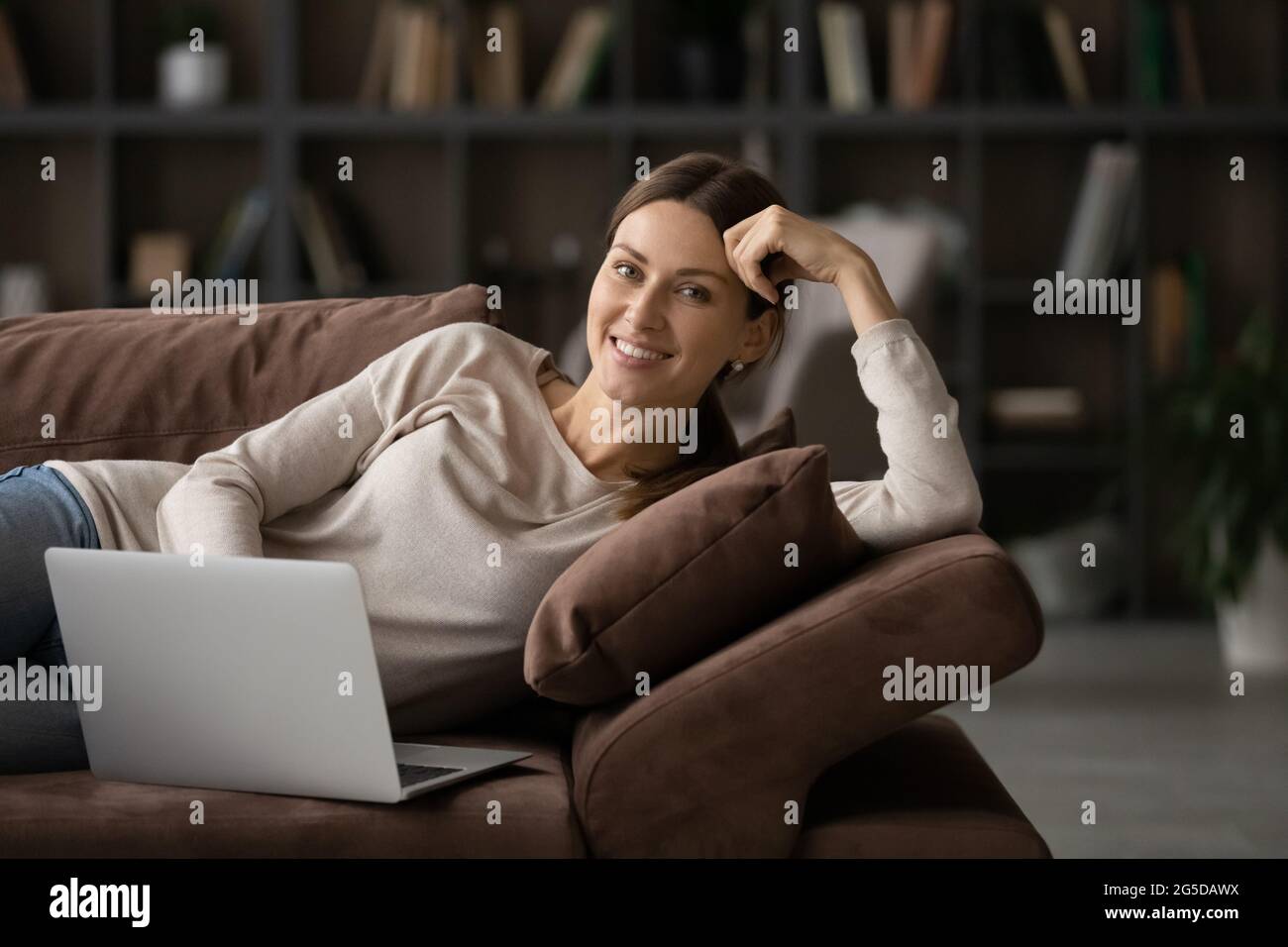 Portrait d'une belle femme souriante utilisant un ordinateur à la maison. Banque D'Images