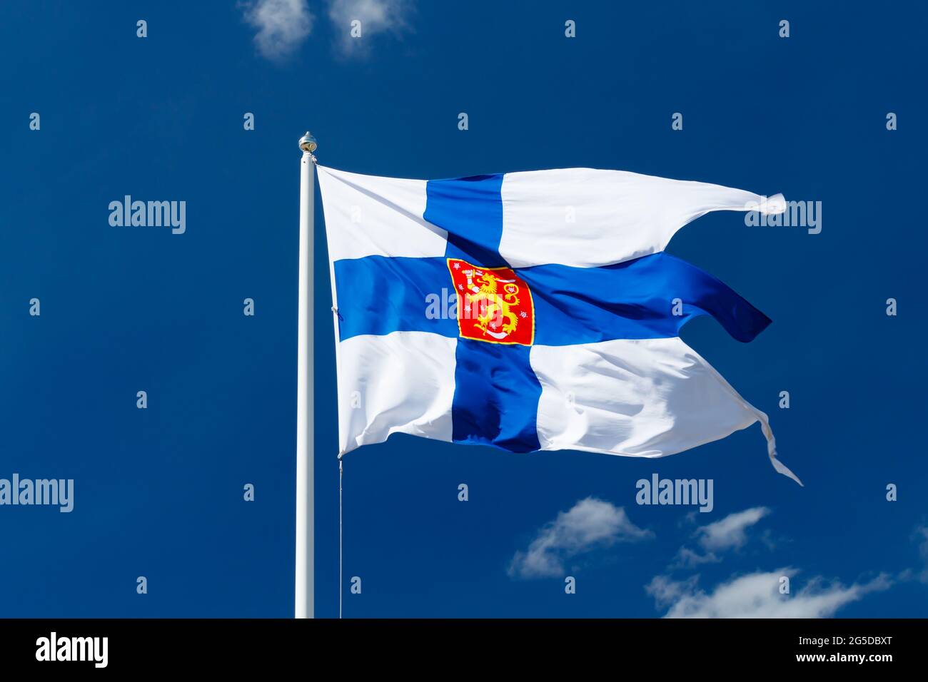 Drapeau national de la Finlande avec armoiries nationales contre le ciel bleu sur le vent Banque D'Images