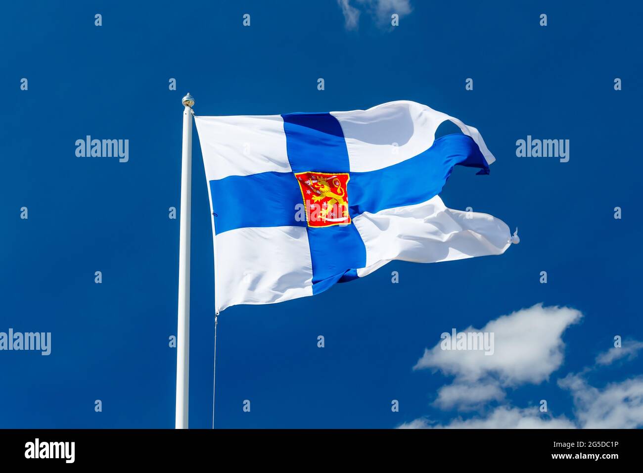 Drapeau national de la Finlande avec armoiries nationales contre le ciel bleu sur le vent Banque D'Images