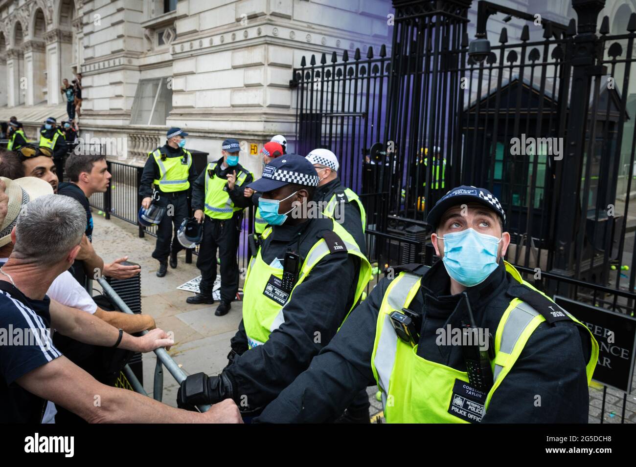 Londres, Royaume-Uni. 26 juin 2021. La police garde la garde tandis que les manifestants d'une manifestation anti-verrouillage lancent des balles de tennis et des grenades de fumée dans Downing Street. Des milliers de personnes ont défilé pour soulever leurs préoccupations concernant la législation gouvernementale centrée sur la vaccination et la liberté de voyager. Credit: Andy Barton/Alay Live News Banque D'Images