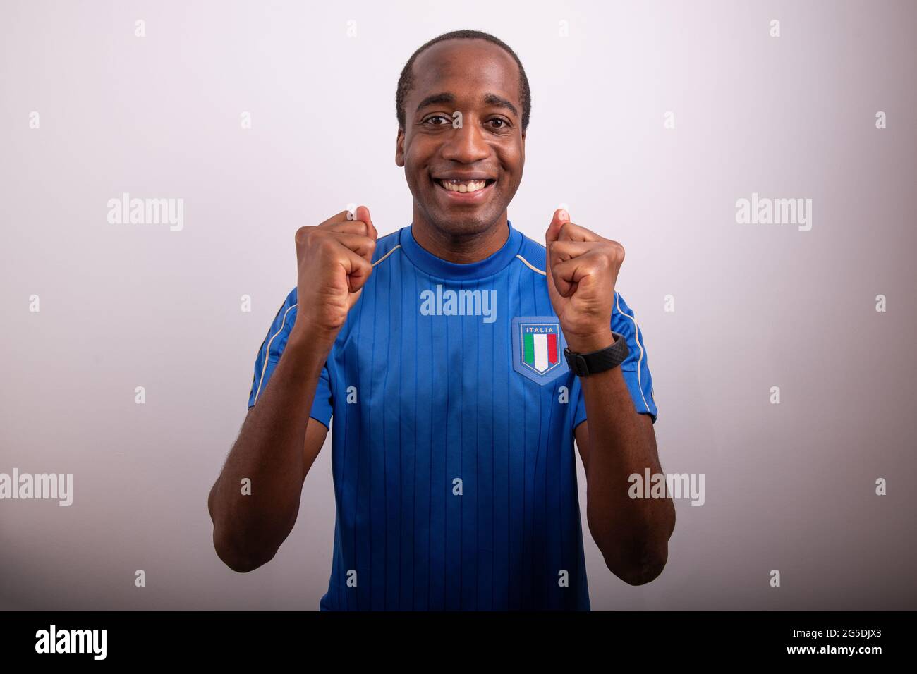 fan italien est heureux pour la victoire de l'italie, fan de fête, afro italien garçon avec le maillot de l'équipe nationale de football Banque D'Images