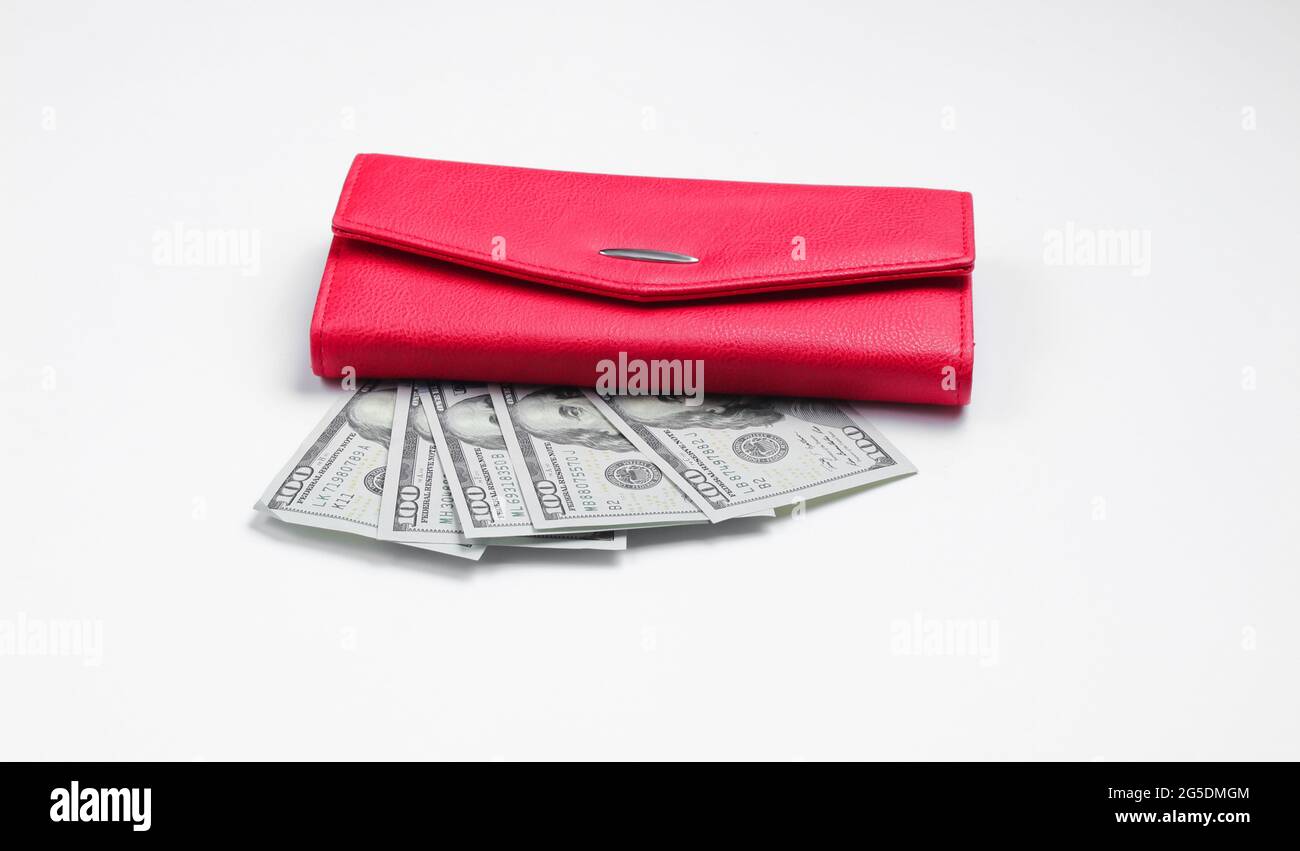 Porte-monnaie rouge et billets de cent dollars sur fond blanc
