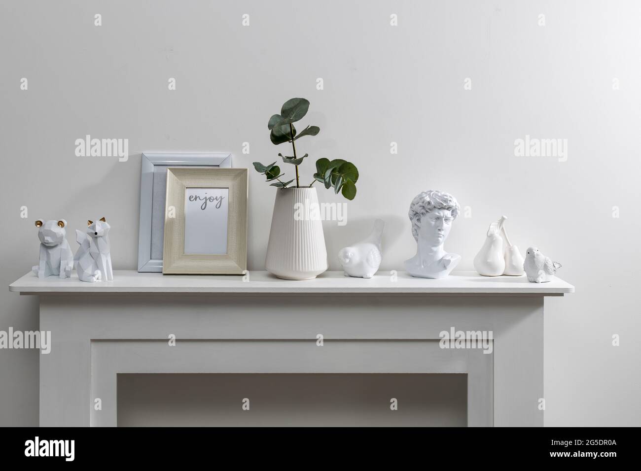 Ensemble de maquettes dorées pour cadres de portrait. Figurines d'ours, renard sur la surface de la commode. Fond de mur blanc. Boho exotique intérieur des Banque D'Images