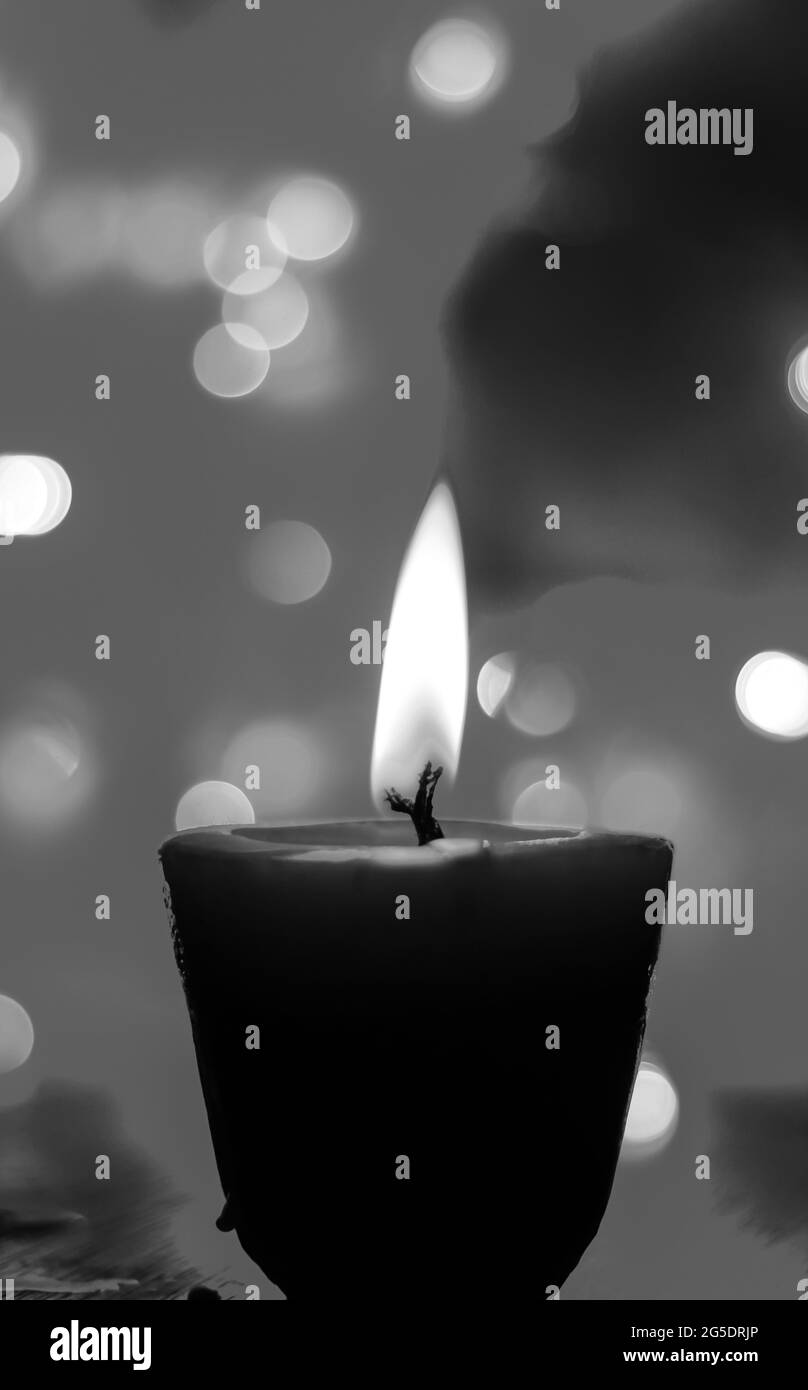Bougies lumineuses dans l'obscurité avec effets de lumière colorés et bokeh pour les moments solennels et le papier peint. Flamme de bougie la nuit avec arrière-plan. Banque D'Images