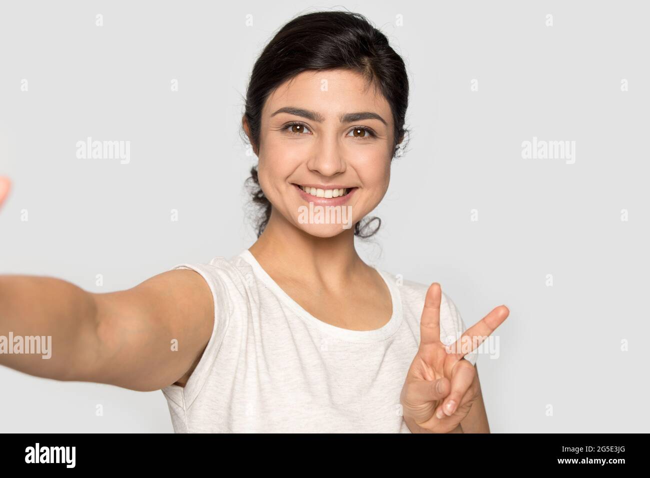 Une femme indienne souriante fait un autoportrait en studio Banque D'Images