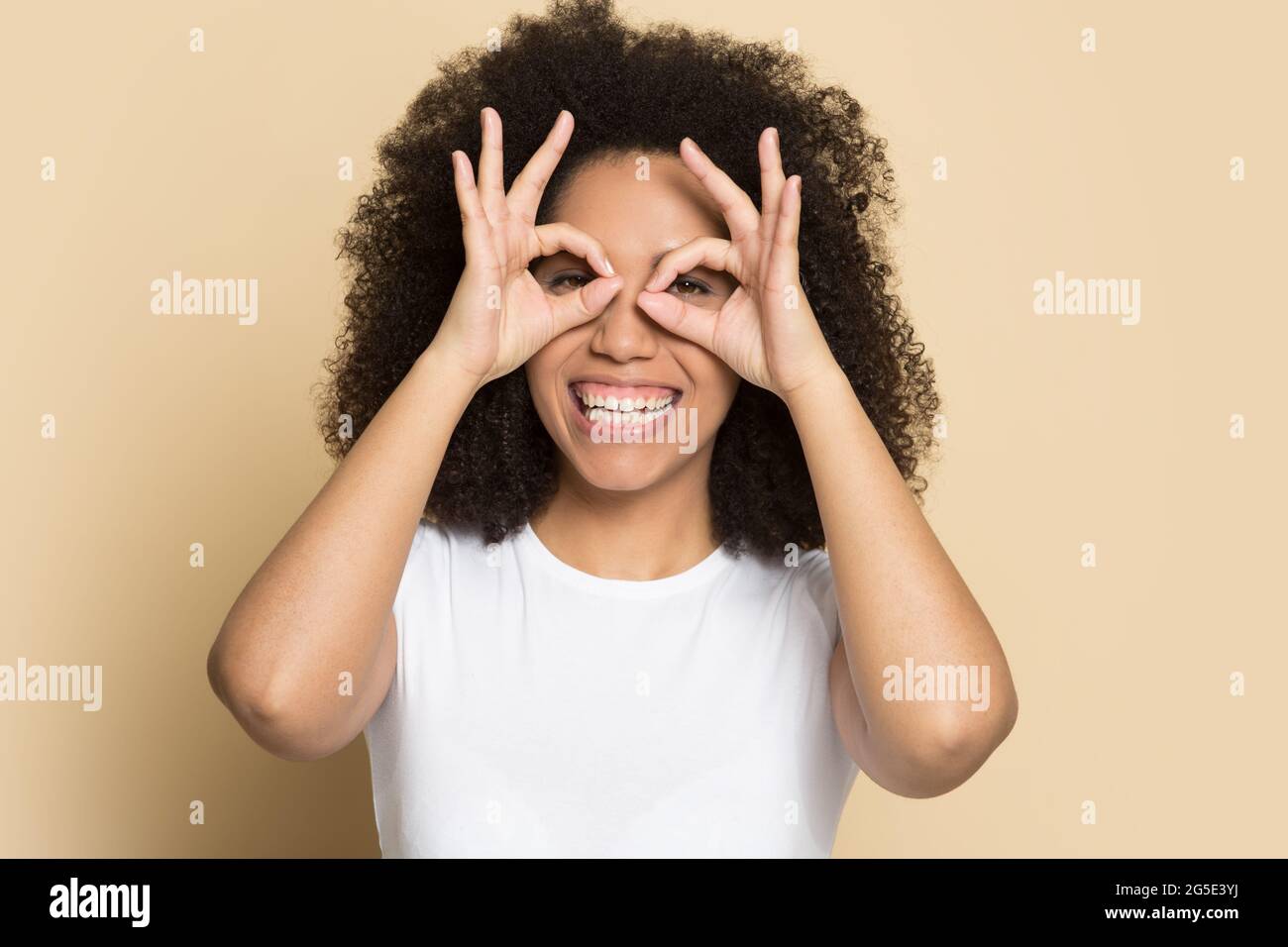 Portrait d'une femme afro-américaine souriante faire des lunettes avec les doigts Banque D'Images