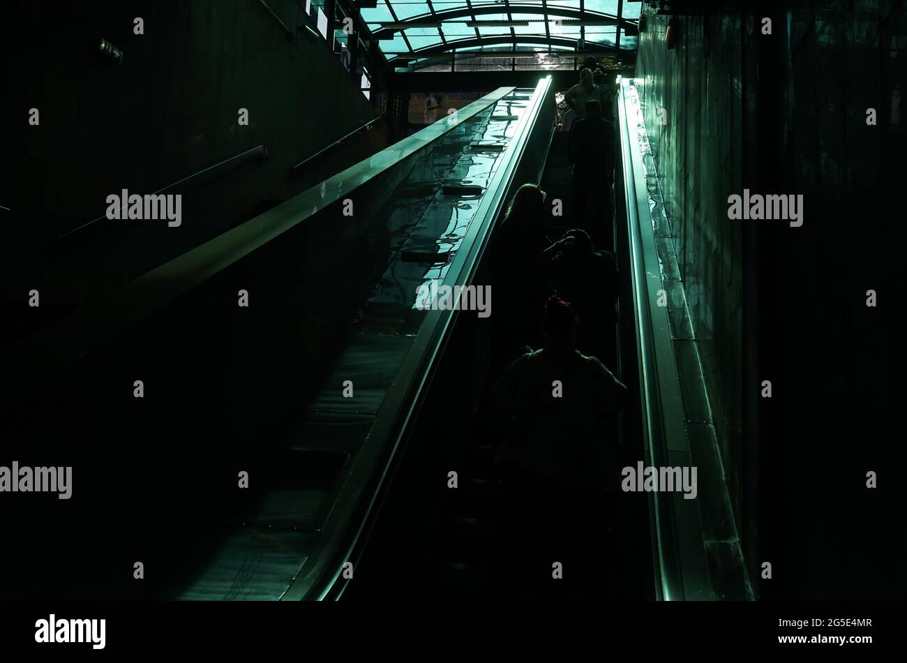 Bucarest, Roumanie - 22 juin 2021: Le reflet de la lumière passant par le plafond vitré brille en fort contraste sur l'escalier roulant à l'e Banque D'Images