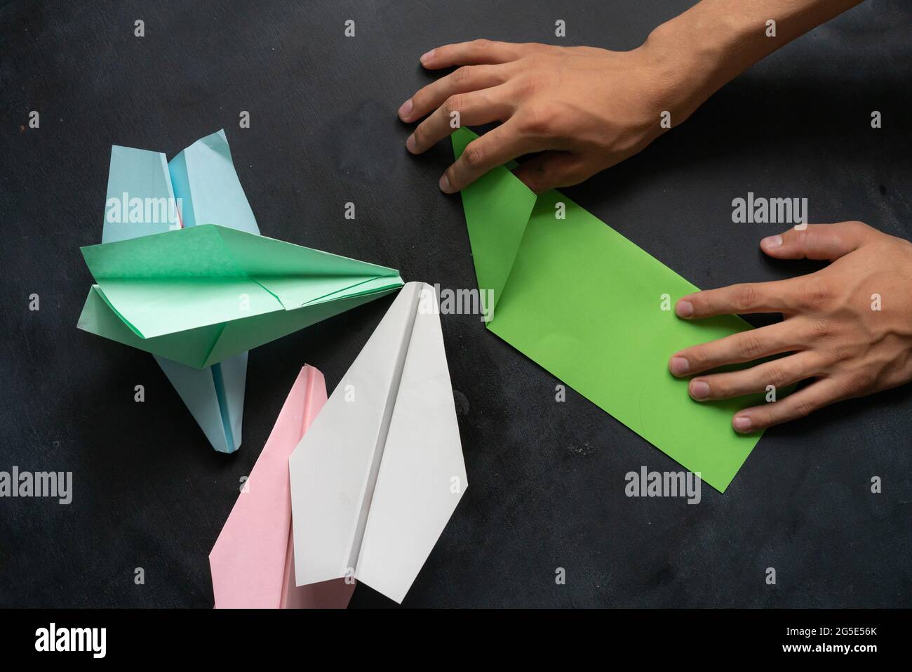 personne mains faisant un avion de papier couleur origami Photo Stock -  Alamy
