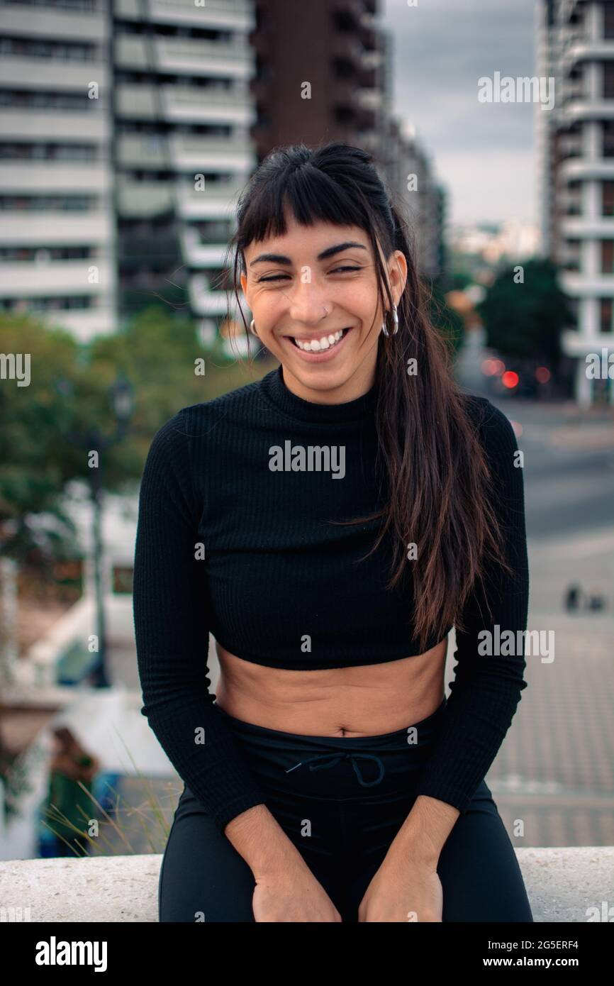 Une photo verticale d une jolie fille Argentine souriant délicieusement dans la ville avec un