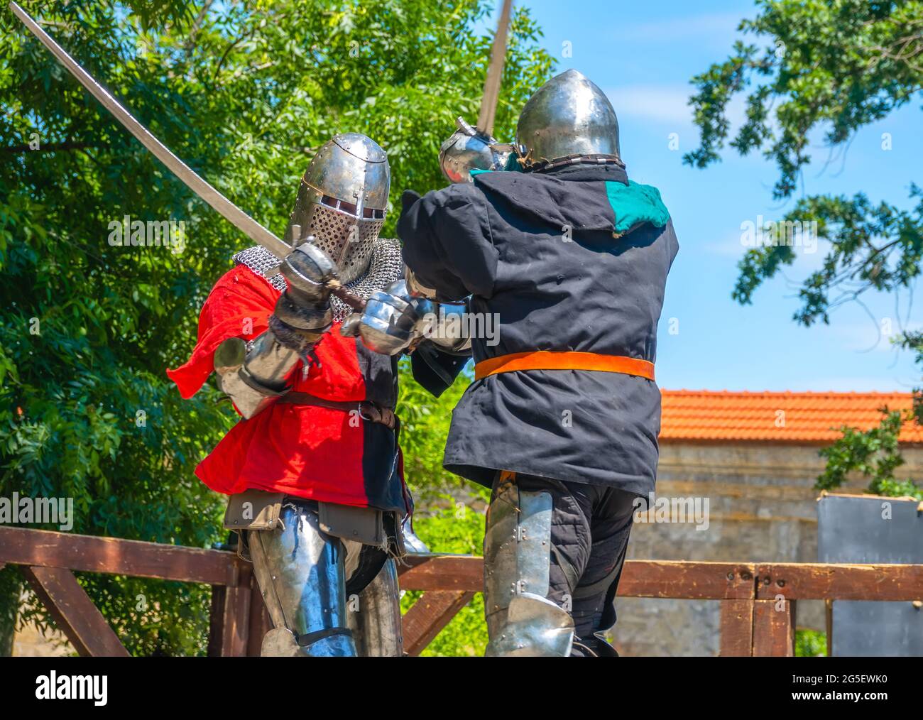 Jour d'été ensoleillé. Deux soldats médiévaux en armure et casques de fer se battent sur des épées Banque D'Images