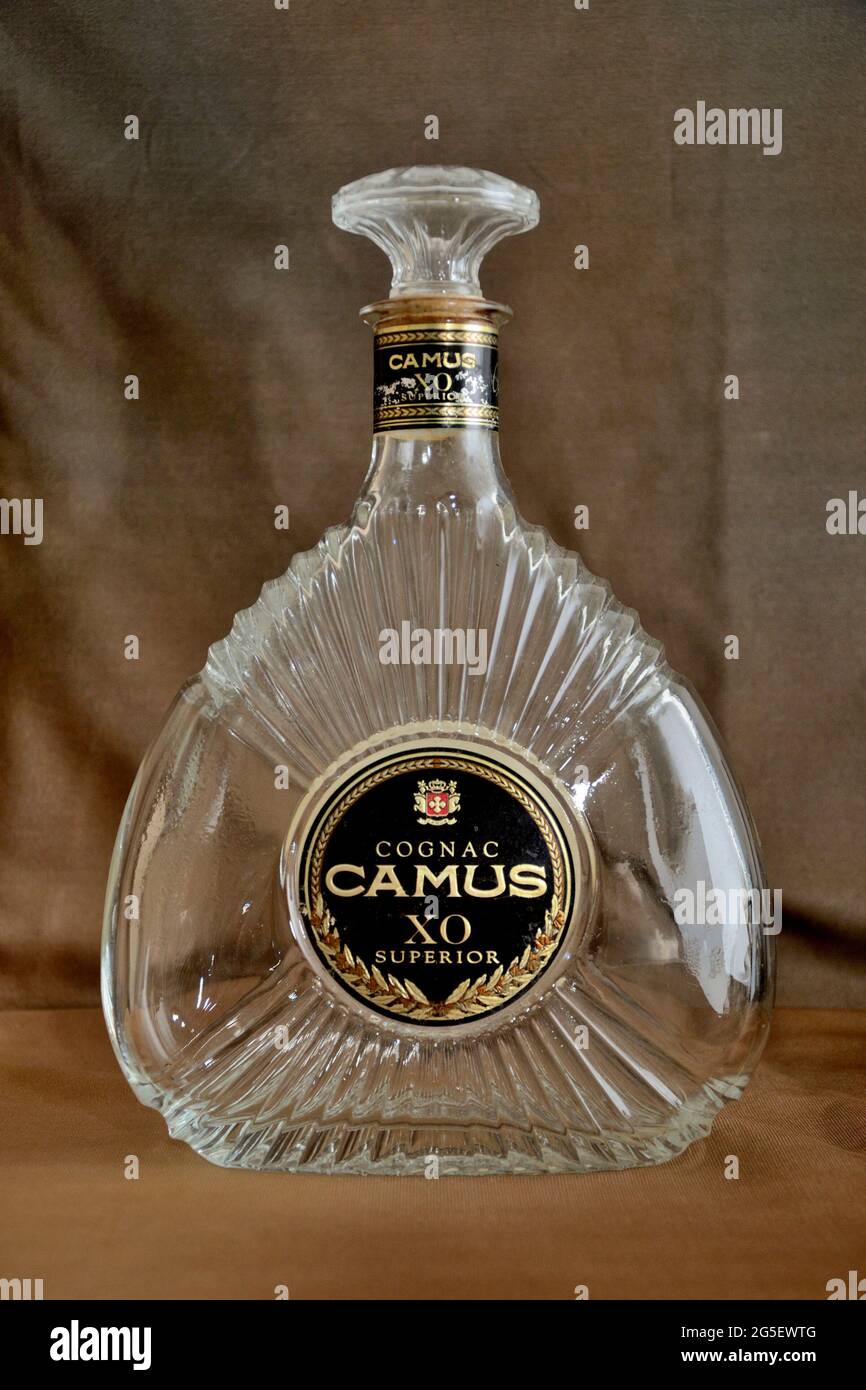 Une bouteille vide de Cognac Camus XO Superior, affichée sur fond marron Banque D'Images