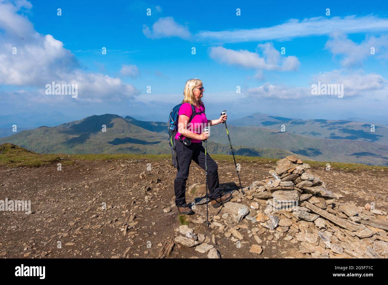 Walker au sommet du cairn de la montagne munro de Meall Corranaich, une partie de la chaîne Ben Lawers en Écosse. La crête de Tarmachan est arrière-plan gauche Banque D'Images