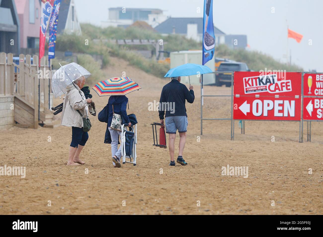 Camber, East Sussex, Royaume-Uni. 27 juin 2021. Météo au Royaume-Uni : le temps pluvieux attendu plus tard est arrivé tôt sur les plages de sable de Camber Sands dans l'est du Sussex. Certaines familles ont l'intention de profiter de la journée lorsqu'elles arrivent avec des parasols et des ponchos de pluie. Crédit photo : Paul Lawrenson /Alay Live News Banque D'Images
